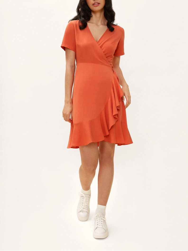 Woman wearing an orange dress on a white background