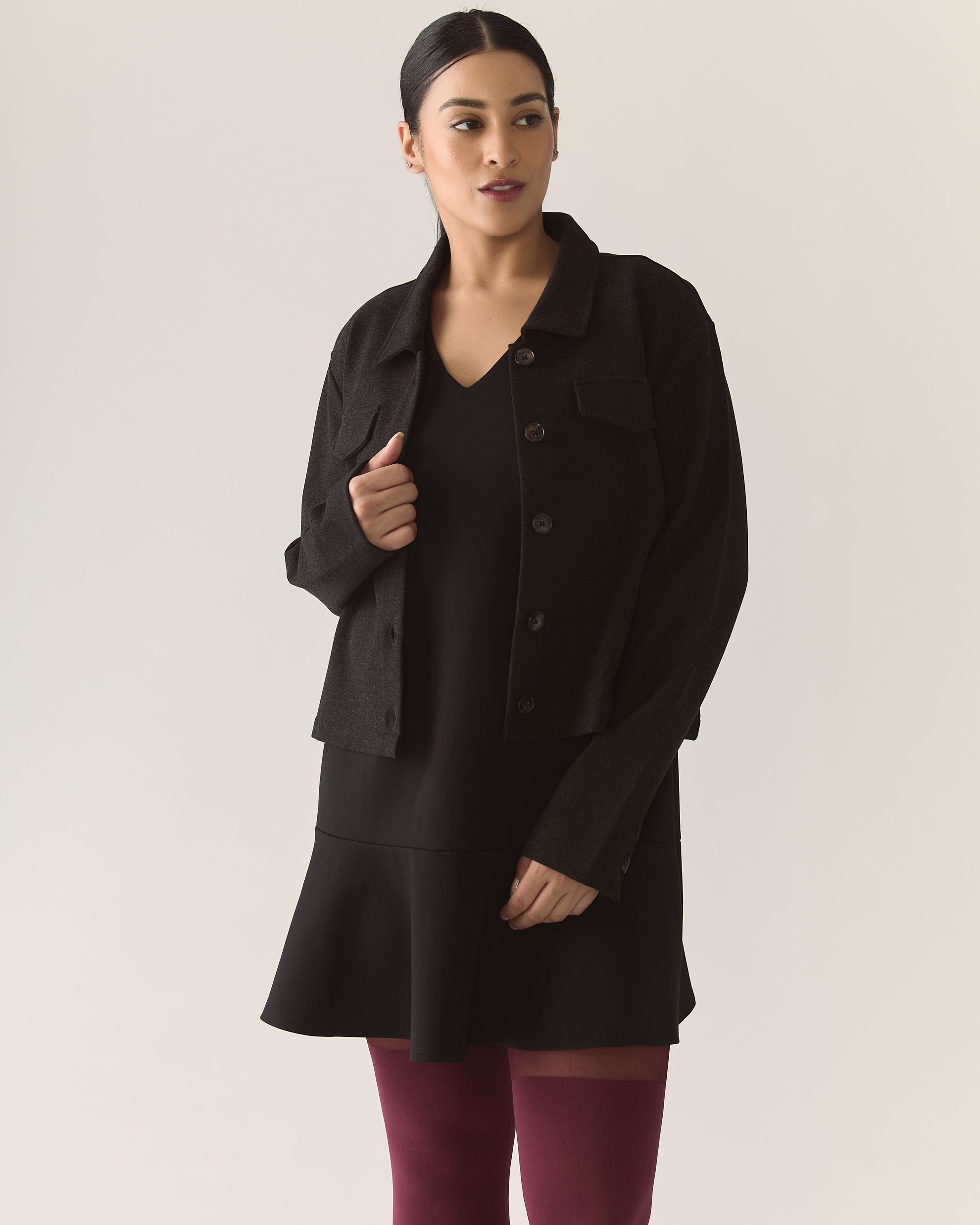 Woman wearing a charcoal cropped overshirt and dress with burgundy tights