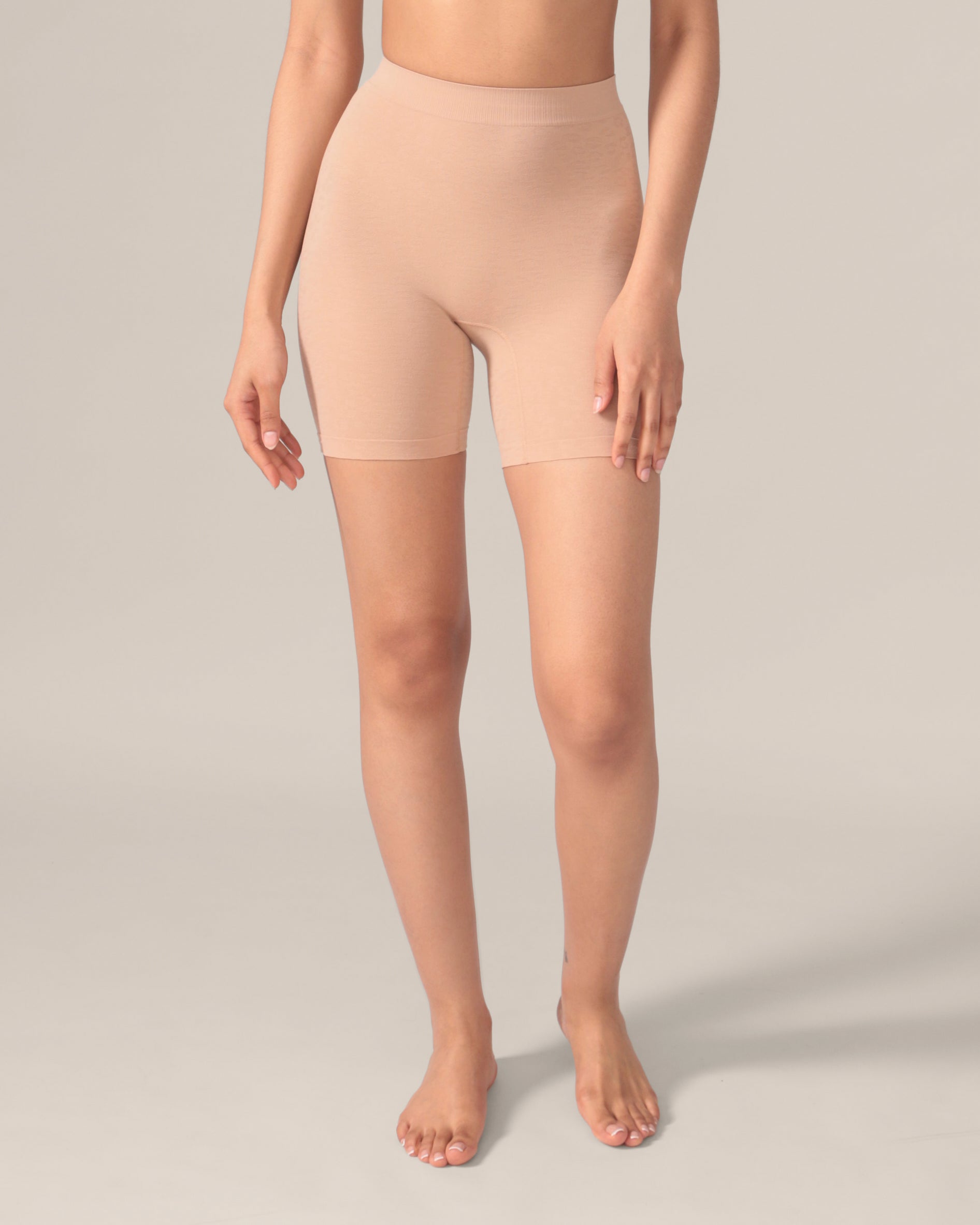 A pair of beige seamless undershorts with a subtle leopard pattern, high-waisted with a 6-inch inseam, displayed on a model.