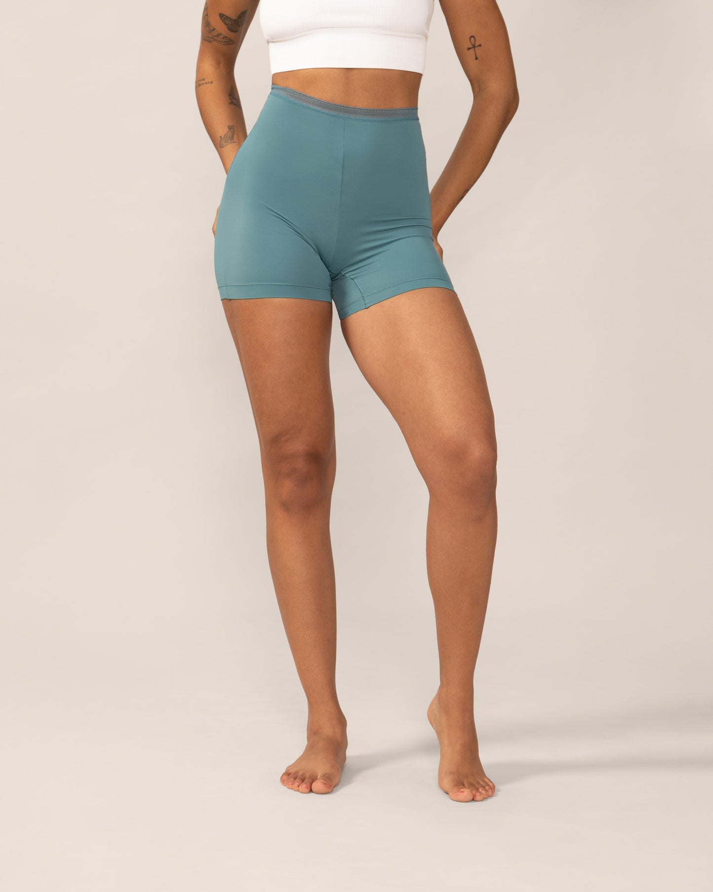 Person wearing teal anti chaffing shorts on a plain background