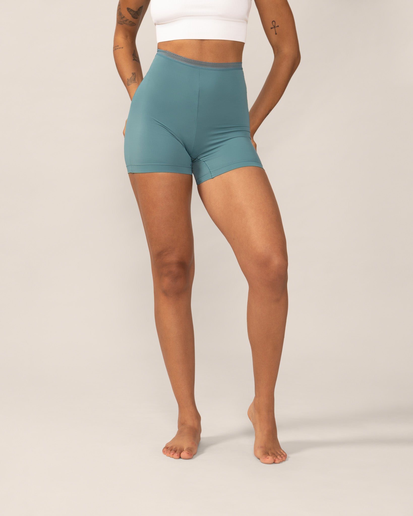Person wearing teal anti chaffing shorts on a plain background