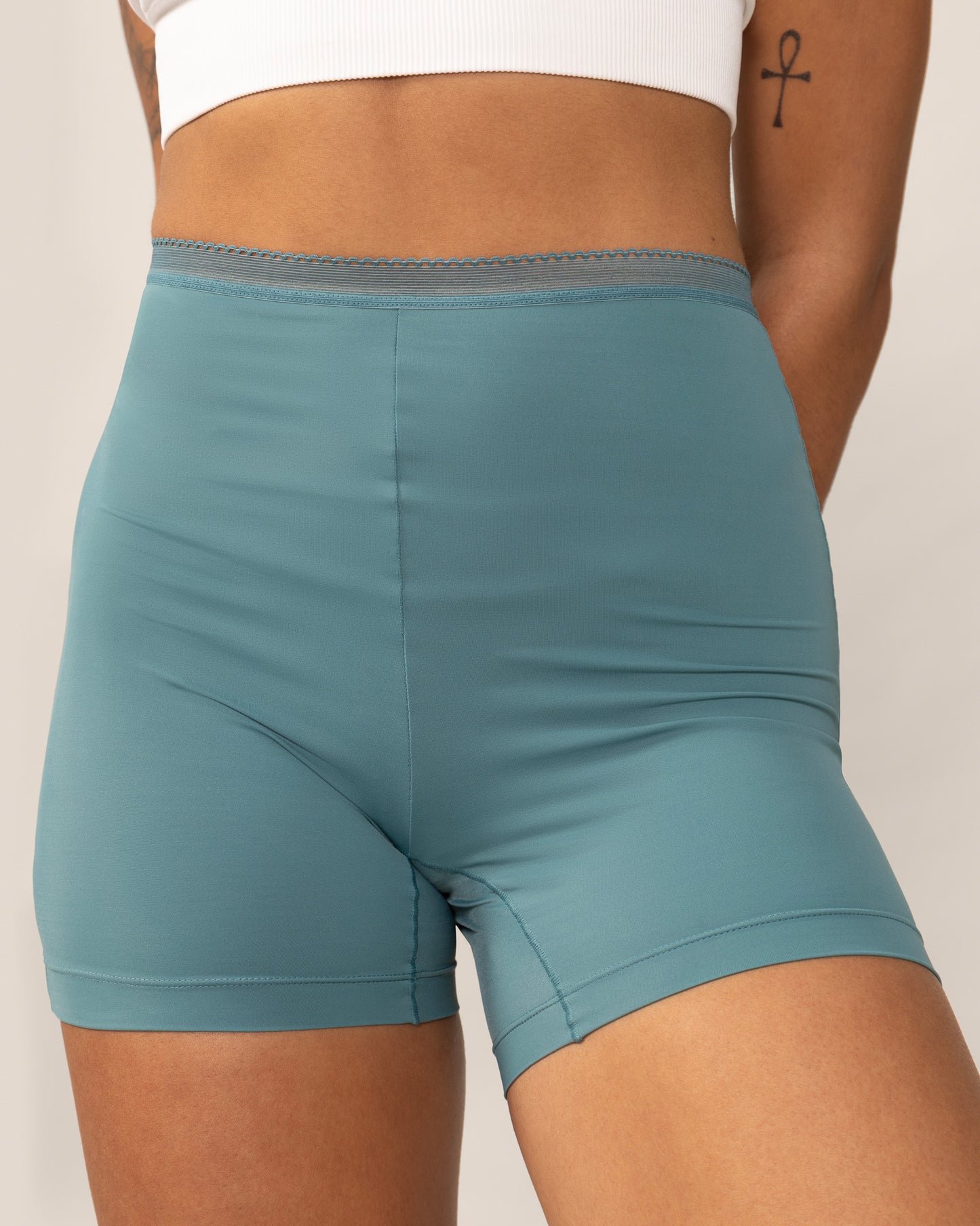 Teal anti chaffing shorts worn by a person on a plain background