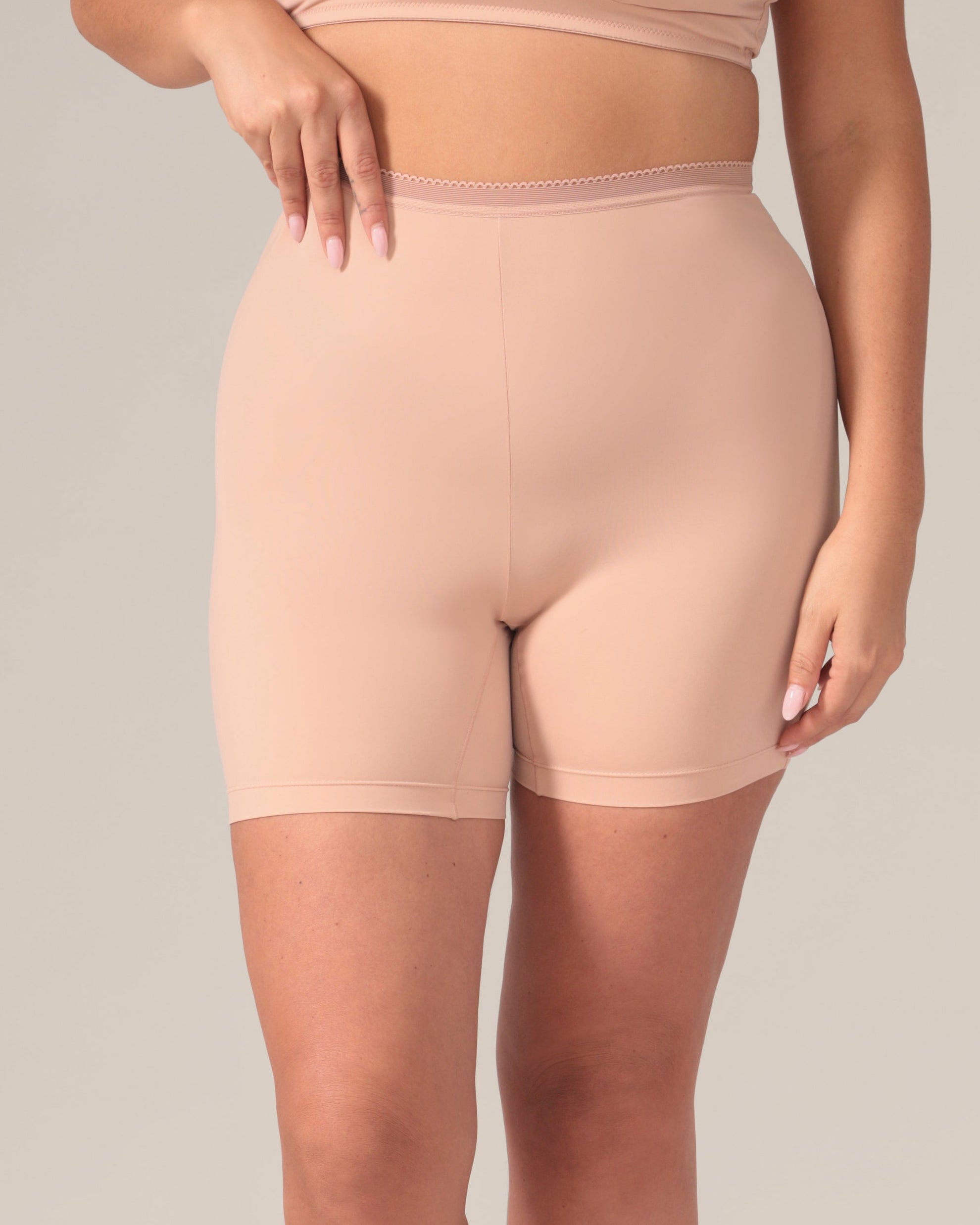 Beige shapewear shorts worn by a person on a neutral background